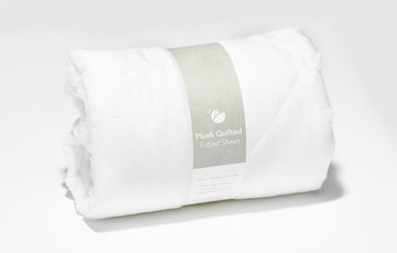 Plush Quilted Crib Sheet rolled up in packaging